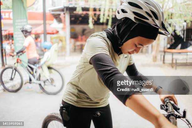 muslimische frau, die mit dem fahrradsport beginnt - baby sturzhelm stock-fotos und bilder
