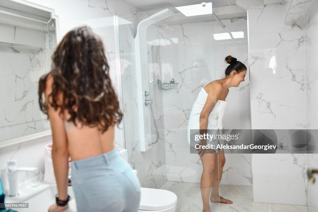 Female In Towel After Shower Laughs While Girlfriend Does Make Up In female-in-towel-after-shower-laughs-while-girlfriend-does-make-up-in