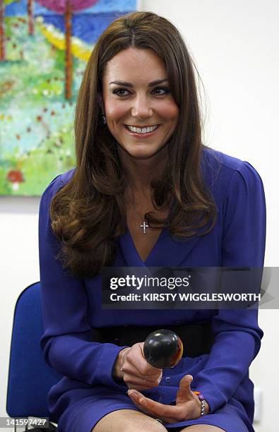 Britain's Catherine, Duchess of Cambridge plays the maracas during a visit to The Treehouse in Ipswich, eastern England, on March 19, 2012. The...