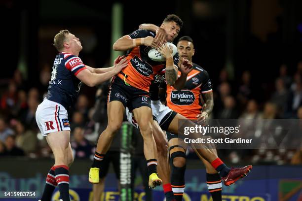 Starford To'a of the Tigers takes the ball mid air during the round 23 NRL match between the Sydney Roosters and the Wests Tigers at Sydney Cricket...