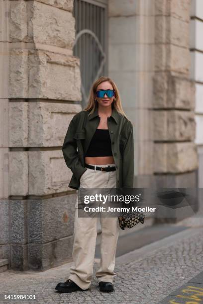 Sonia Lyson wearing Gucci black leather loafer, Zara low waist cargo beige pants, vintage black Dior belt, Zara black cropped top, Prada checked mini...
