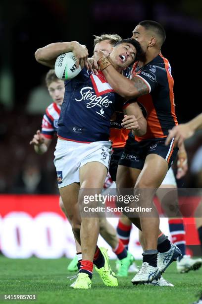 Joseph Suaalii of the Roosters is tackled by Joe Ofahengaue of the Tigers during the round 23 NRL match between the Sydney Roosters and the Wests...
