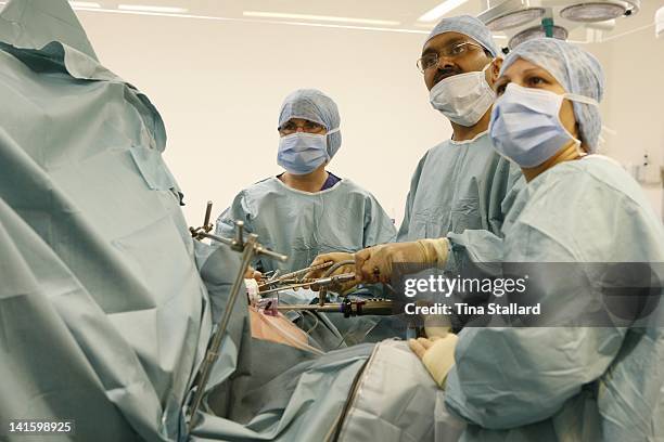Surgeon and nurses carry out laparoscopic surgery to fit a gastric band. The probes allow the surgery to be done through small incisions in the...