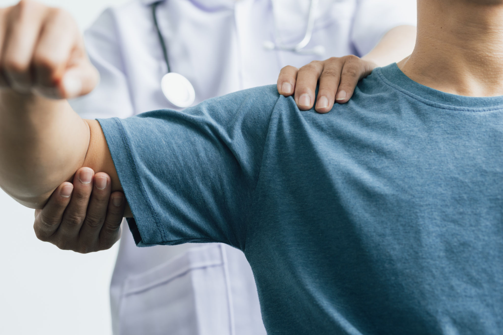 A man with shoulder pain goes to the doctor, The doctor diagnoses the patient's arm pain and shoulder pain. Concept of physical therapy and rehabilitation. A man with shoulder pain goes to the doctor, The doctor diagnoses the patient's arm pain and shoulder pain. Concept of physical therapy and rehabilitation.