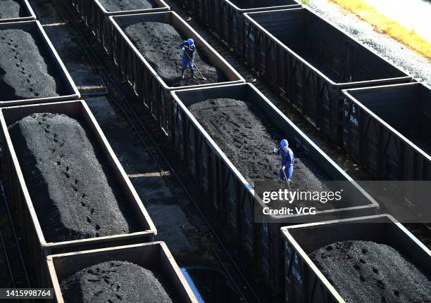 Employees work on a freight train loaded with coal at Jiangxi Coal Reserve Center on August 19, 2022 in Jiujiang, Jiangxi Province of China.