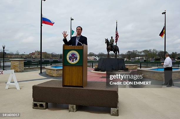 Presidential candidate Rick Santorum delivers a speech in front of a statue of former US President Ronald Reagan March 19, 2012 in Dixon, Illinois....