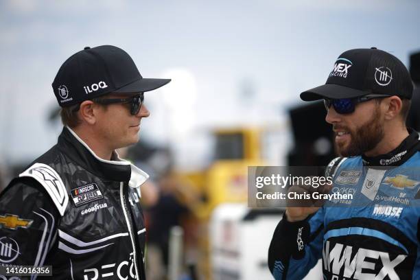 Kimi Raikkonen, driver of the Recogni Chevrolet, and Ross Chastain, driver of the Worldwide Express Chevrolet, talk in the garage area during...