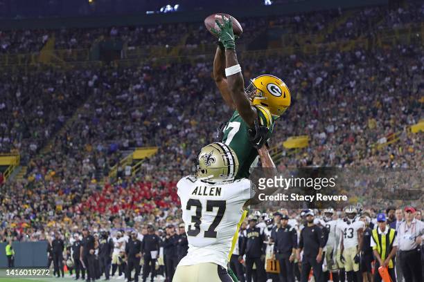 Romeo Doubs of the Green Bay Packers catches a pass for a touchdown over Brian Allen of the New Orleans Saints during the first half of a preseason...