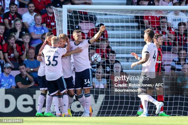 Martin Ødegaard of Arsenal is congratulated by team-mates after he scores his second to make it 2-0 during the Premier League match between AFC...
