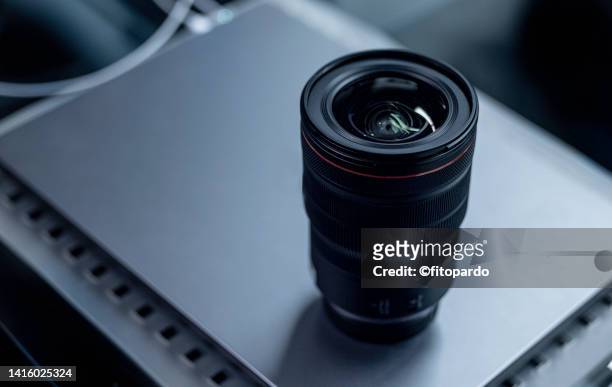 a camera lens over a computer - digitale spiegelreflexcamera stockfoto's en -beelden