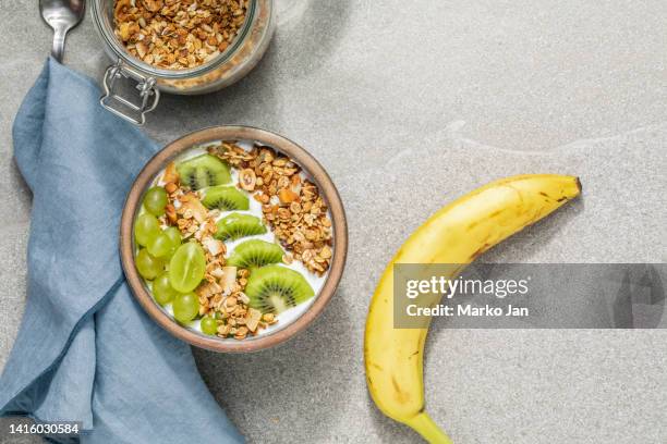 pasto di avena sano con uva, kiwi e banana, su un moderno tavolo da cucina - daylight saving time foto e immagini stock