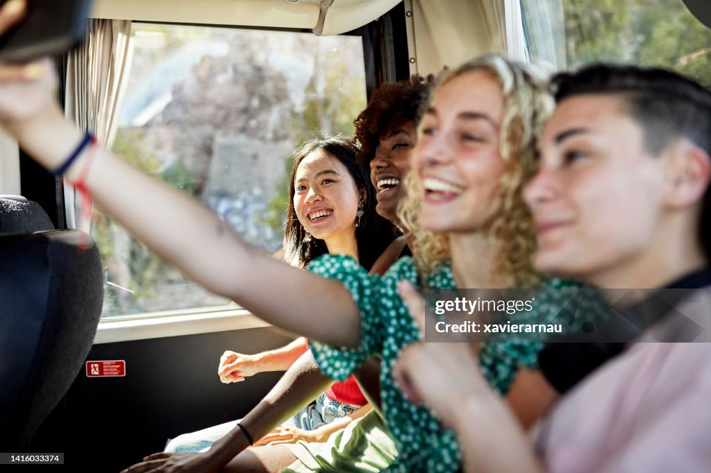 Glückliche Freundinnen, die Selfie an Bord des Reisebusses machen