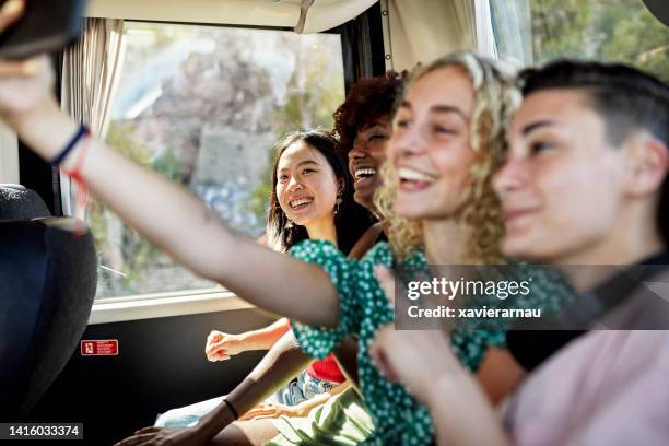 happy female friends taking selfie onboard coach bus - journey together stock pictures, royalty-free photos & images