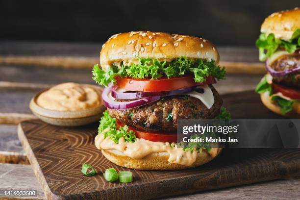 leckerer hamburger auf dunklem hintergrund - burger stock-fotos und bilder