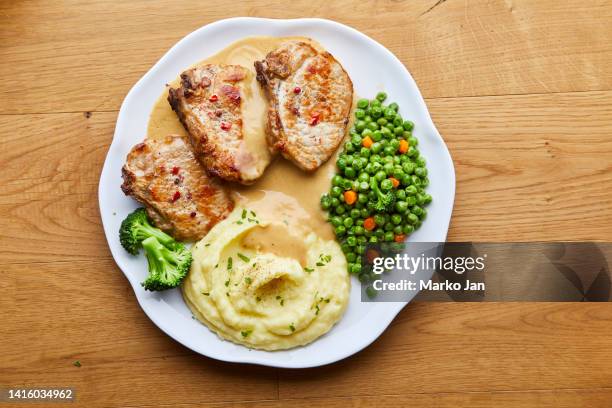 fried meat steaks and mashed potato with peas and sauce on a plate - pureed 個照片及圖片檔