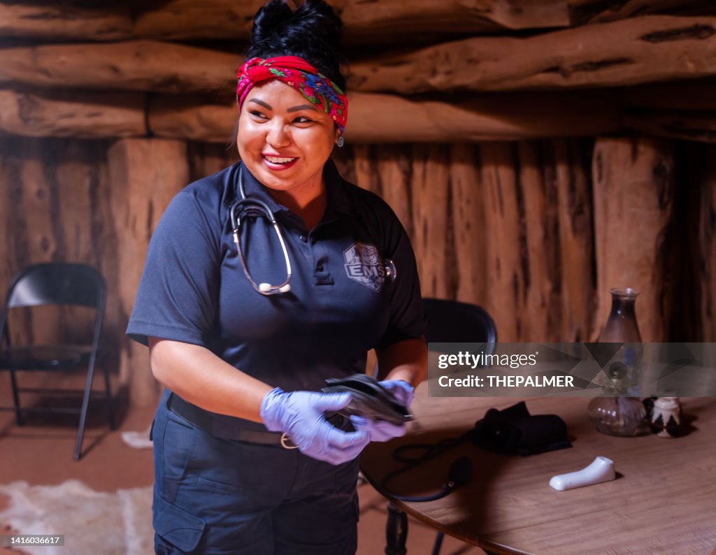 Young navajo female paramedic visiting a navajo hogan