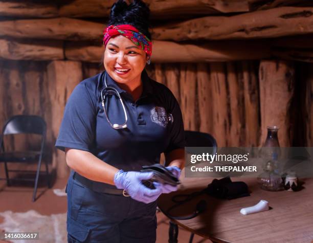 young navajo female paramedic visiting a navajo hogan - traditional native american medicine stock pictures, royalty-free photos & images