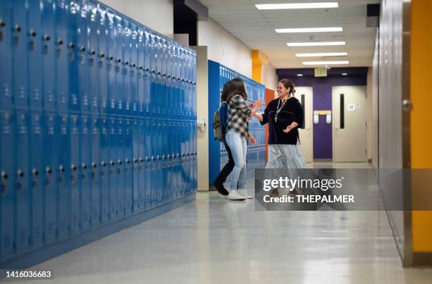 teacher saying goodbye to a couple of students outside the classroom - heritage hall stock pictures, royalty-free photos & images