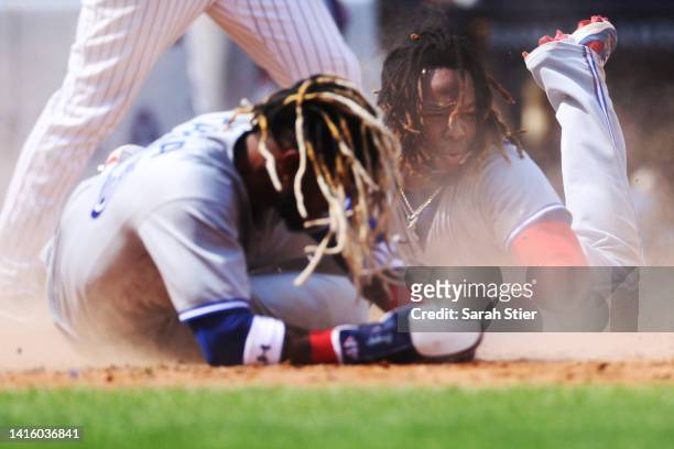 Vladimir Guerrero Jr. #27 of the Toronto Blue Jays collides with Raimel Tapia of the Toronto Blue Jays sliding into home during the fifth inning...