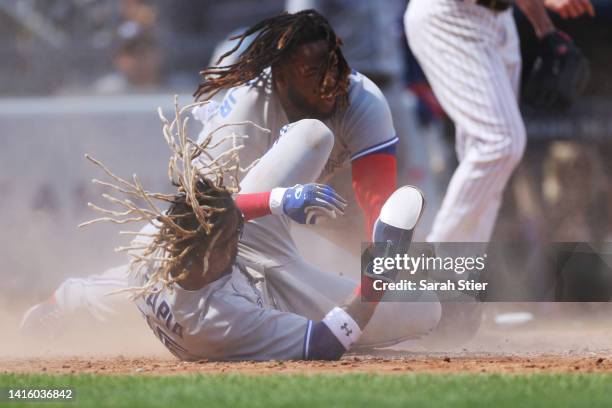 Vladimir Guerrero Jr. #27 of the Toronto Blue Jays collides with Raimel Tapia of the Toronto Blue Jays sliding into home during the fifth inning...