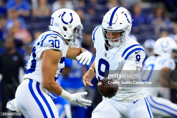 Nick Foles of the Indianapolis Colts hands the ball off to Phillip Lindsay in the first quarter during the preseason game against the Detroit Lions...