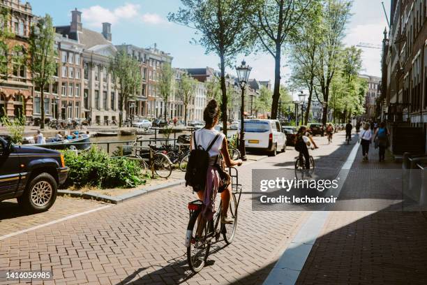 cycling commute in amsterdam, the netherlands - canal stock pictures, royalty-free photos & images