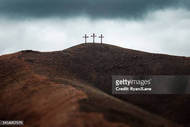 three crosses on dark hillside - images of jesus on the cross at calvary imagens e fotografias de stock