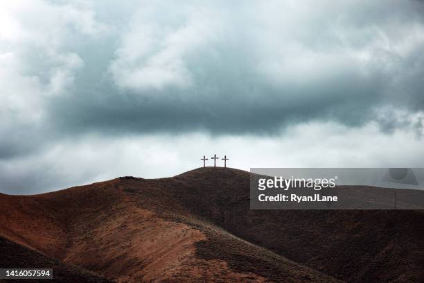 three crosses on dark hillside - death and resurrection of jesus stockfoto's en -beelden
