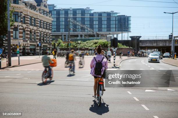 woman cycling in amsterdam, the netherlands - city on the move bildbanksfoton och bilder