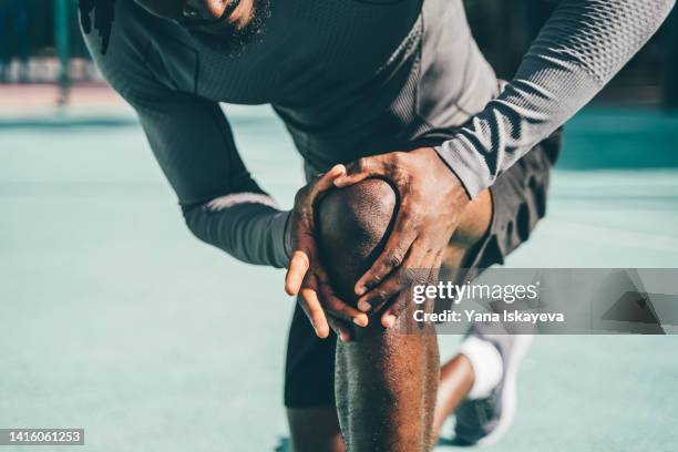 active sportsman having a knee pain during training - calcio sport imagens e fotografias de stock