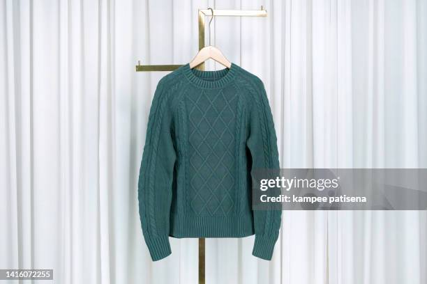 green color sweater hanging on rack at home - jersey de cuello alto fotografías e imágenes de stock