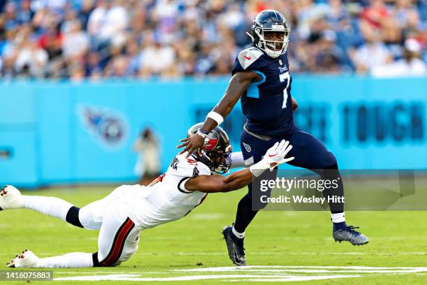 Malik Willis of the Tennessee Titans avoids the sack from the rush of Joe Tryon-Shoyinka of the Tampa Bay Buccaneers during a preseason game at...