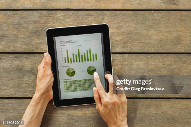 person's hands holding tablet with touch screen. wooden background with copy space. - electronic organizer stock pictures, royalty-free photos & images