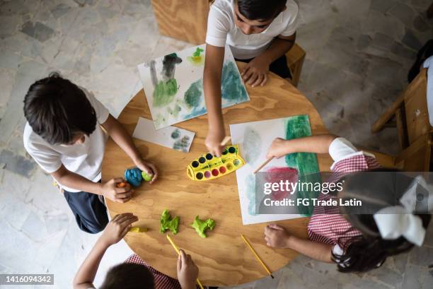 students painting in the classroom at school - tiny mexican girl stock pictures, royalty-free photos & images