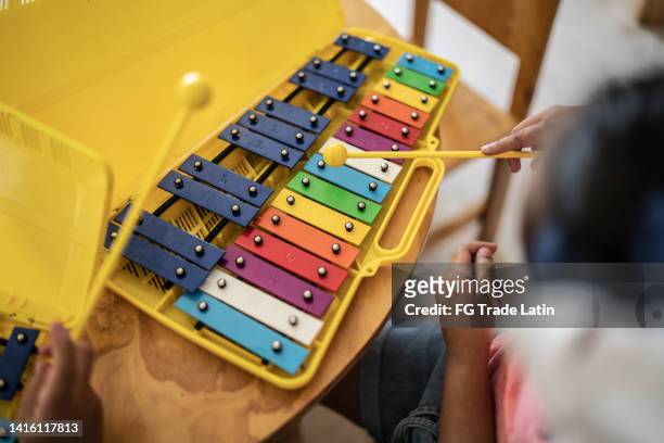 nahaufnahme von schülern, die musikinstrument im klassenzimmer in der schule spielen - xylophone stock-fotos und bilder