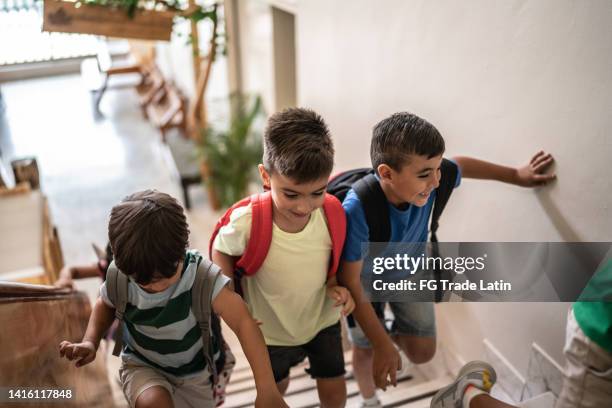 students moving up stairs and arriving at school - boy brown hair stock pictures, royalty-free photos & images