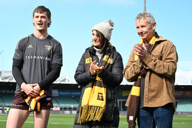 Ned Long of the Hawks is presented with his game jersey during the round 23 AFL match between the Hawthorn Hawks and the Western Bulldogs at...