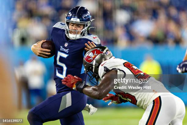 Logan Woodside of the Tennessee Titans runs the ball during a preseason game and is knocked out of bounds by Olakunie Fatukasi of the Tampa Bay...