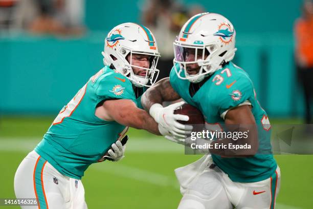 Skylar Thompson of the Miami Dolphins hands off the football to Myles Gaskin during the fourth quarter against the Las Vegas Raiders at Hard Rock...