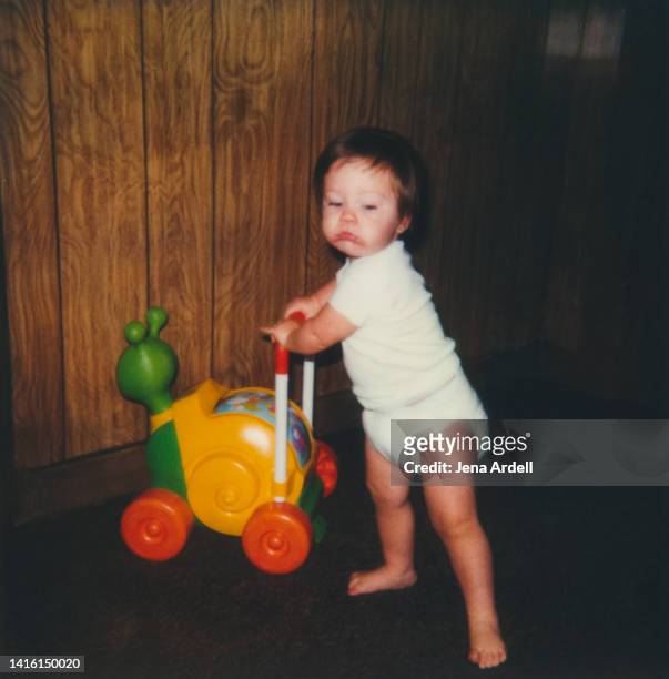 vintage baby photo: vintage child playing with toy, 1980s kid childhood - retro boy stock-fotos und bilder