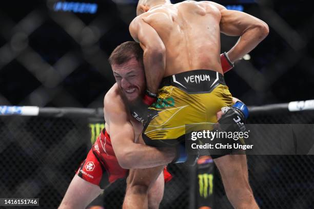 Merab Dvalishvili of Georgia attempts a takedown against Jose Aldo of Brazil in a bantamweight fight during the UFC 278 event at Vivint Arena on...