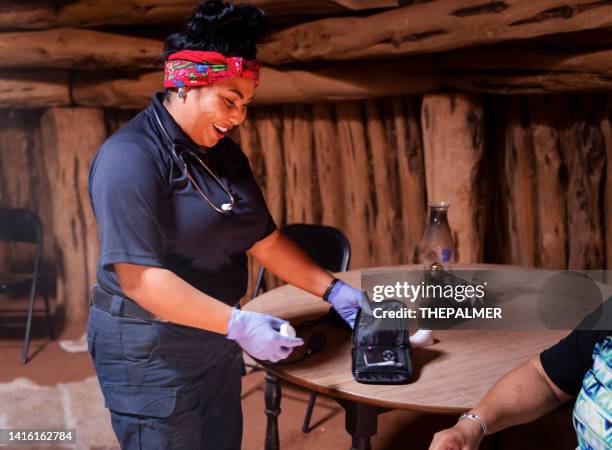 young female paramedic preparing to do a blood glucose test - native american reservation stockfoto's en -beelden