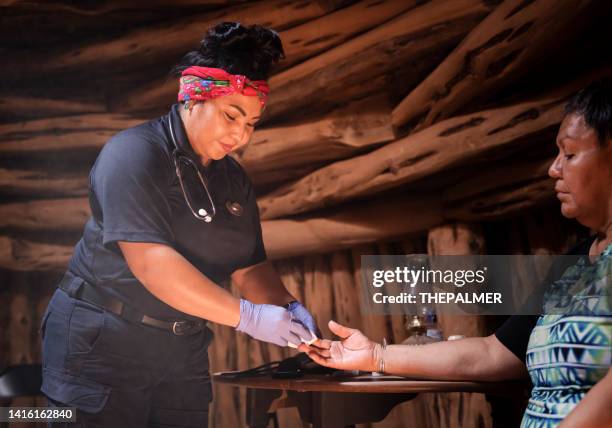 young emergency medical technician (ems) visiting patient at home - traditional native american medicine stock pictures, royalty-free photos & images