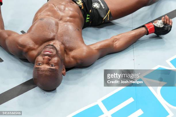 Kamaru Usman of Nigeria lies on the Octagon mat after being knocked out by Leon Edwards of Jamaica in the UFC welterweight championship fight during...