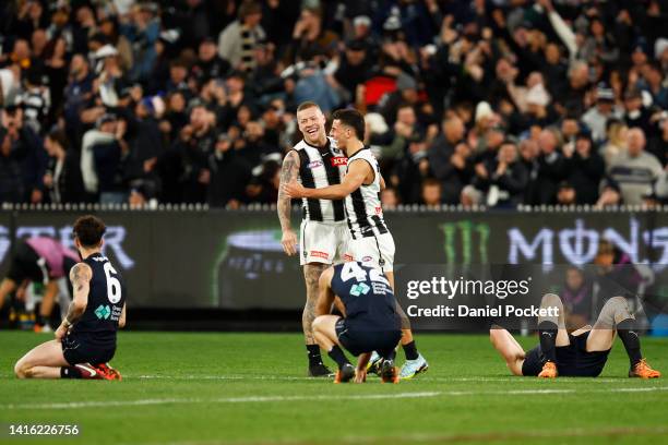 Jordan De Goey of the Magpies and Nick Daicos of the Magpies celebrate on the final siren after winning the round 23 AFL match between the Carlton...