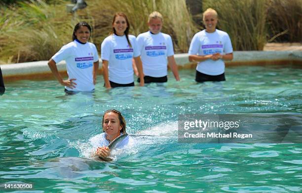 Gisela Dulko of Argentina swims with a dolphin during a visit to the Miami Seaquarium on Day 2 of the Sony Ericsson Open on March 20, 2012 in Key...