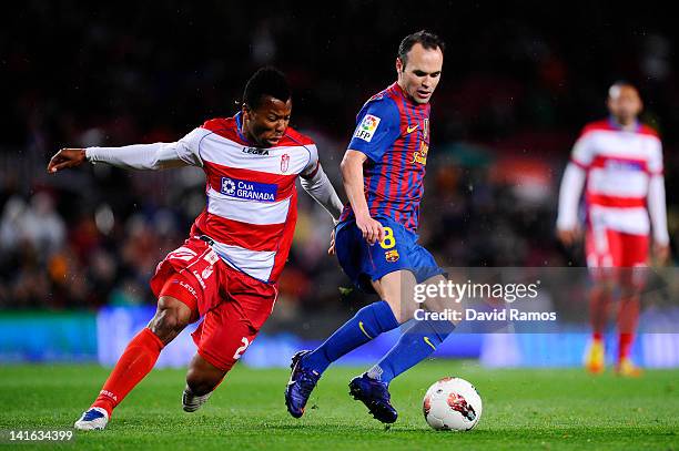 Andres Iniesta of FC Barcelona duels for the ball with Ikechukwu Uche of Granada CF during the La Liga match between FC Barcelona and Granada CF at...