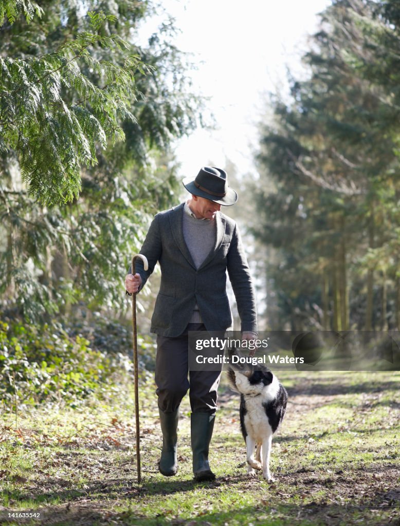 Farmer walking in countryside with dog