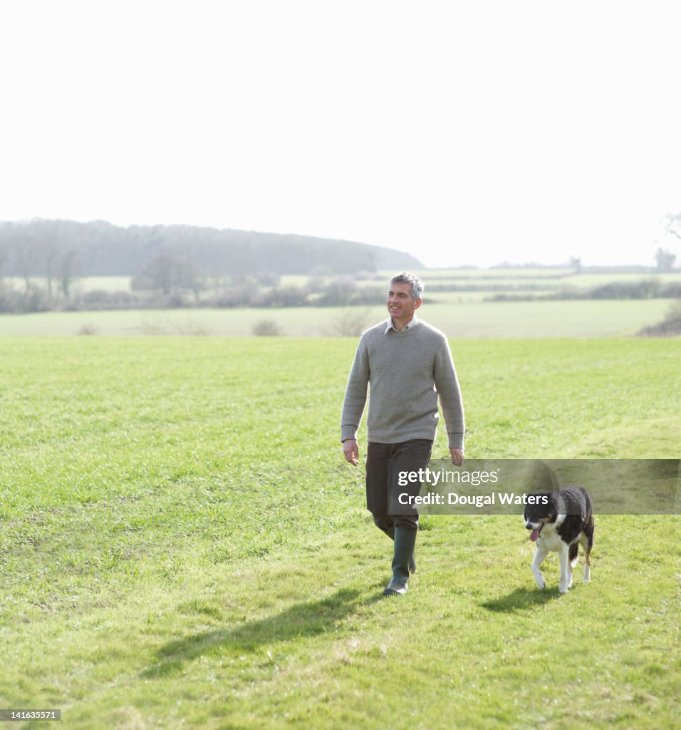 Man walking in countryside with pet dog