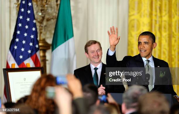 President Barack Obama waves as he concludes remarks with Irish Prime Minister Enda Kenny who presented Obama with a certificate of Irish heritage...